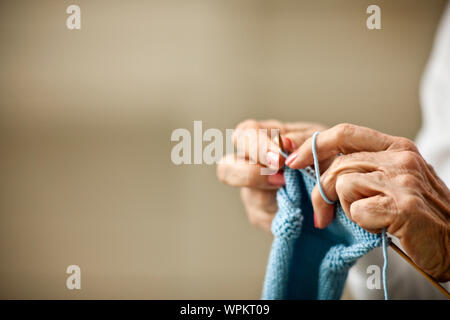 Nahaufnahmen der Hände der älteren Frau, als sie strickt. Stockfoto