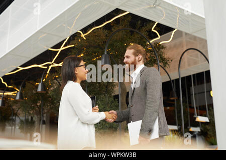 Young Business Paar stehen und die Hände schütteln Sie begrüssung vor dem business meeting in der Nähe des Restaurant Stockfoto