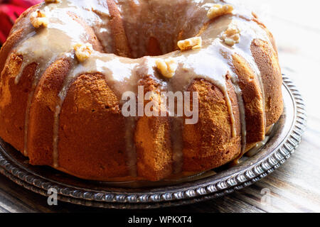 Lecker, Pumpkin Spice Bundt Cake matt mit braunem Zucker Glasur und Walnüsse Backofen ein rustikales Holz Tisch Hintergrund. Stockfoto