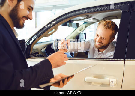 Eine junge Frau ein Auto kauft in einem Autohaus. Stockfoto