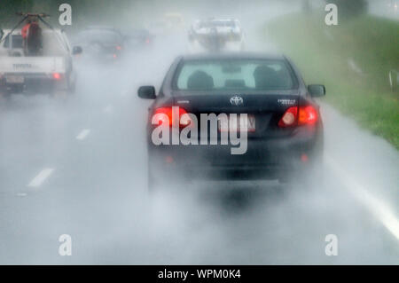 Führende Verkehr senden Strahlen Wasser auf die Windschutzscheibe eines Fahrzeugs nach einem heftigen Regenguss auf dem warrego Highway zwischen Toowoomba und Bri Stockfoto