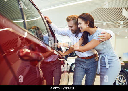 Junges Paar ein neues Auto in Showroom wählen. Stockfoto