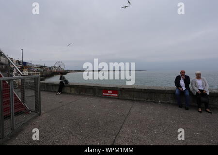 Blick entlang nach Norden Bridlington Beach vom Hafen genommen. Im Vordergrund sind zwei Personen. Stockfoto