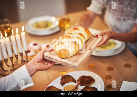 Chanukka Abendessen. Familie versammelt um den Tisch teilen challah Stockfoto