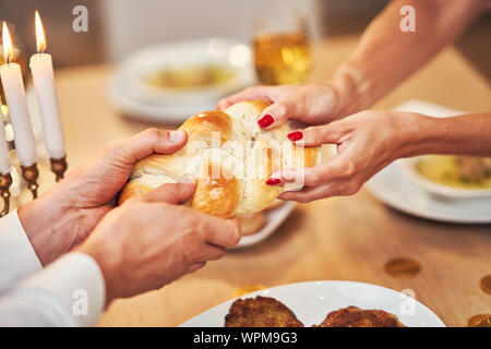 Chanukka Abendessen. Familie versammelt um den Tisch teilen challah Stockfoto