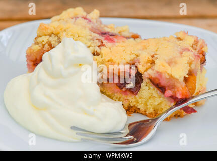 08 September 2019, Brandenburg, Sieversdorf: ein Stück frisch gebackenen Pflaumenkuchen mit Streusel und Schlagsahne liegt auf einer Platte. Foto: Patrick Pleul/dpa-Zentralbild/ZB Stockfoto