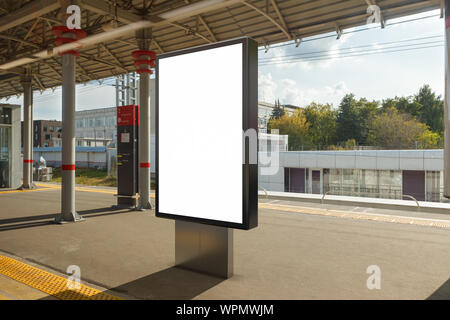 Ein Plakatstand mit leeren Reklametafeln steht auf dem Bahnsteig des Bahnhofs. Stockfoto