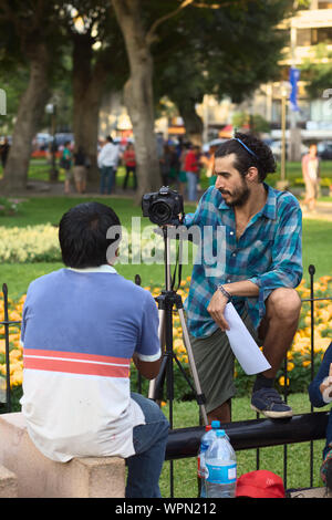 LIMA, PERU - 3. MÄRZ 2012: Unbekannter junger Mann ein Foto von einer anderen Person mit einer Canon EOS 60D Kamera im Parque Kennedy Stockfoto