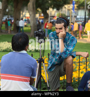 LIMA, PERU - 3. MÄRZ 2012: Unbekannter junger Mann ein Foto von einer anderen Person mit einer Canon EOS 60D Kamera im Parque Kennedy Stockfoto