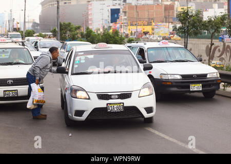 LIMA, PERU - 21. JULI 2013: unbekannter Mann bitten, ein Taxi für die Fahrt auf der Av. Paseo de La Republica im Zentrum der Stadt am 21. Juli 2013 in Lima, Peru Stockfoto