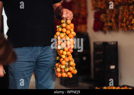 Apulien/ITALIEN - AUGUST 2019: Die alte Tradition der hängenden Kirschtomaten auf der Wand sie für wintrr Zeit im Süden Italiens zu erhalten Stockfoto