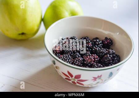 Eine Schale mit frisch gepflückten Brombeeren und kochen Äpfel. Stockfoto