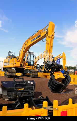 Hyvinkää, Finnland. September 6, 2019. Komatsu HB 215 LC Hybrid Baggerführers zeigt große Präzision durch Entnahme von Pack Karten mit den Ringen. Stockfoto