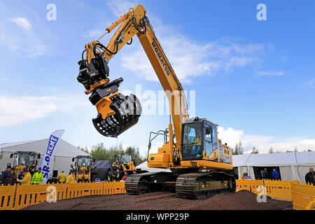 Hyvinkää, Finnland. September 6, 2019. Komatsu HB 215 LC Hybrid Baggerführers zeigt große Präzision durch Entnahme von Pack Karten mit den Ringen. Stockfoto