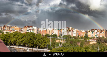 Atemberaubende rainbow erscheinen durch die Wolken nach einem Gewitter in einer Stadt. Bild in Esplugues de Llobregat, Spanien. Stockfoto