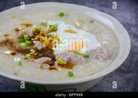 Congee, Reisbrei mit Schweinehack, gekochtes Ei, tolles Frühstück. Stockfoto