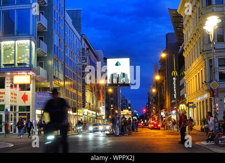 Berlin, Deutschland. 19 Aug, 2019. Ein Radfahrer fährt abends von Zimmerstraße bis Friedrichstraße. In der Mitte der Straße steht das ehemalige Alliierte Checkpoint Checkpoint Charlie. Der bekannteste Grenzübergang in Berlin war nur offen für Ausländer, Diplomaten und Mitglieder der alliierten Streitkräfte. Credit: Soeren Stache/dpa-Zentralbild/ZB/dpa/Alamy leben Nachrichten Stockfoto