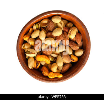 Gemischte Nüsse in einem braunen Keramik Schüssel auf weißem Hintergrund. Gesunde Snacks und Lebensmittel. Gesalzen und würzigen Pistazien, Cashewkerne und Mandel. Ansicht von oben. Stockfoto