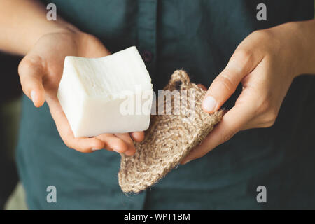 Umweltfreundliche Reinigungsmittel Kit. Organische Seife und Jute Waschlappen in die Hand der Frau. Null Abfall Konzept, Kunststoff, eco-friendly Shopping, vegan Stockfoto