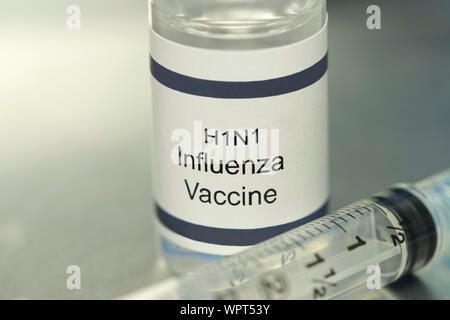 Der Grippe H1N1-Impfstoff auf silbernem Tablett mit Spritze. Stockfoto