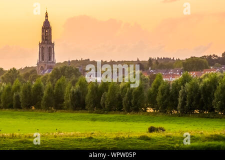 Blick auf die Stadt Rhenen mit Kirchturm bei Sonnenuntergang, Schöne rustikale Stadt in den Niederlanden Stockfoto