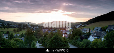 Weiten Panoramablick über die bergige Dorf von Grafschaft im Winter Sport Region Sauerland, Deutschland, bei Sonnenuntergang Stockfoto