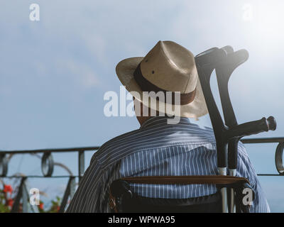Senior mit Rollstuhl sitzen draußen in der Sonne Stockfoto
