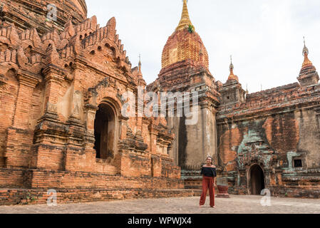 Horizontale Bild von Touristen vor der alten Tempel im Archäologischen Park in Bagan, Myanmar entfernt Posing Stockfoto