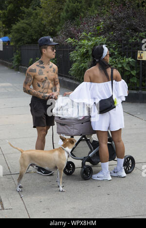 Die jährlichen Universal Hip Hop Parade für Soziale Gerechtigkeit statt zu Ehren von Marcus Garvey in der Bedford Stuyvesant Nachbarschaft von Brooklyn, New York. Tätowierten Mann seinen Hund in der Nachbarschaft. Stockfoto