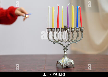 Jüdische Frau Beleuchtung Hanukkah Kerzen in einem MENORAH. Hanukkah jüdische Feiertag gefeiert, acht Tage zur Markierung der 8 Tage Öl verbrannt. Stockfoto