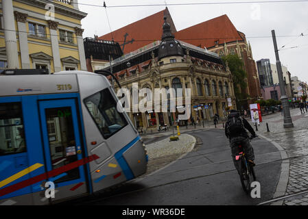 Wroclaw, Polen. 07 Sep, 2019. Ein Mann auf einem Fahrrad neben der Straßenbahn in die Altstadt. Breslau ist die viertgrößte Stadt in Polen und die grösste Stadt in der Region von Schlesien. Breslau Breslau oder in deutscher Sprache verbrachte mehr als 200 Jahre unter deutscher Herrschaft, aber nach dem Zweiten Weltkrieg der Region unter polnische Behörde durch das Potsdamer Abkommen unter territorialen Veränderungen von der Sowjetunion gefordert wurde. Credit: SOPA Images Limited/Alamy leben Nachrichten Stockfoto