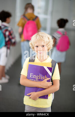 Blonde Schüler halten Englische Grammatik Buch Stockfoto