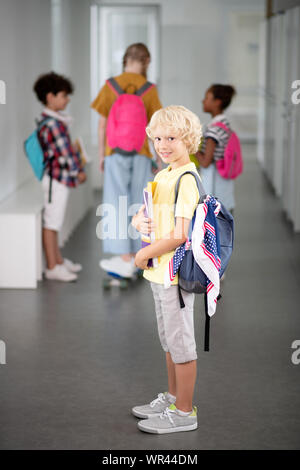 Süße Junge mit Rucksack in die Schule Flur Stockfoto