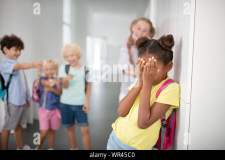 Dunkelhäutige Mädchen schließen ihr Gesicht, während leiden unter Mobbing Stockfoto