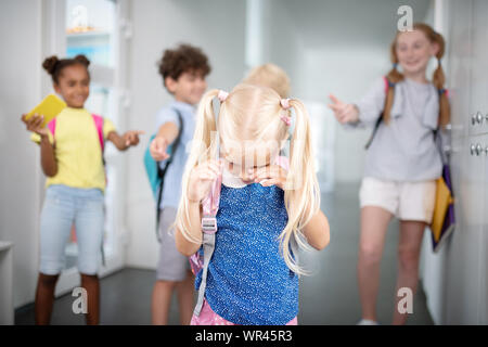 Kleines Mädchen schreien und fühlen sich von den Mitschülern beleidigt Stockfoto