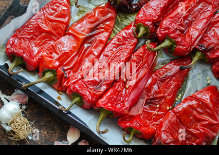 Geröstete Paprika für den Winter Vorbereitung auf hölzernen Tisch. Stockfoto