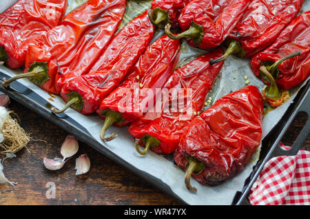 Geröstete Paprika für den Winter Vorbereitung auf hölzernen Tisch. Stockfoto