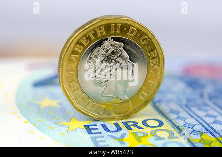 Einpfundstück auf 20 Euro Banknote. Konzept für Geldwechsel, Finanzen und BREXIT. Makro Foto mit geringer Tiefenschärfe. Stockfoto