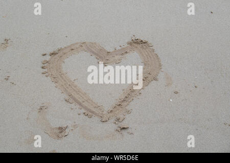 Herz im Sand am Strand, wie romantisch - Nordirland, Großbritannien gezogen. Stockfoto