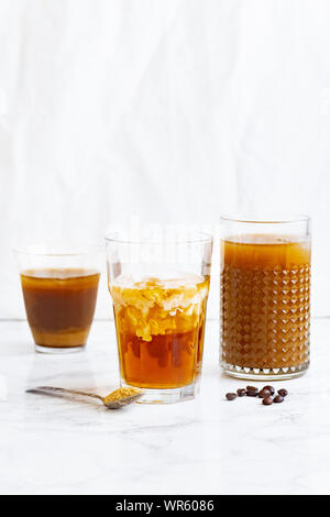 Eiskaffee mit Sahne und Vanille in verschiedene Gläser auf weißem Hintergrund. Sommer Cocktail oder Dessert Stockfoto