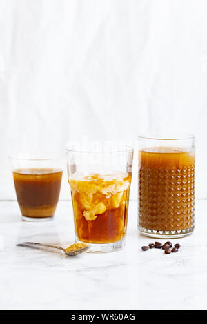 Eiskaffee mit Sahne und Vanille in verschiedene Gläser auf weißem Hintergrund. Sommer Cocktail oder Dessert Stockfoto