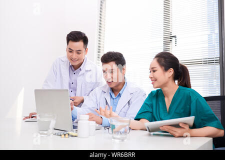 Krankenhaus, Beruf, Menschen und Medizin Konzept - Gruppe von Happy Ärzte mit Tablet PC-Computer treffen in medizinischen Büro Stockfoto