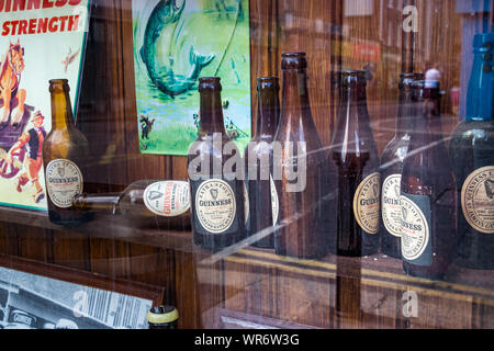 Dublin, Irland - 28. Juli 2019: Gruppe von Guinness Glas Bier Flaschen auf dem Schaufenster einer Bar in Dublin, Irland. Stockfoto