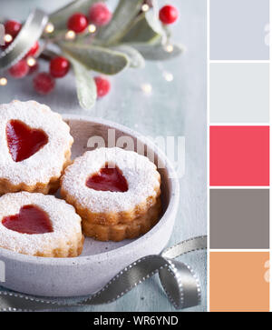 Farblich passende Palette von Foto von Weihnachten Linzer marmelade Cookies in Beton Glas mit Weihnachten Dekorationen, Beleuchtung, Mistel und berris Stockfoto