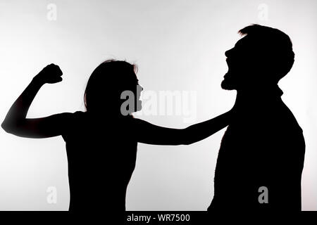 Häusliche Gewalt und Misshandlungen Konzept - Silhouette einer Frau schlagen einen Mann. Stockfoto