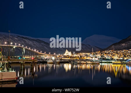 Panorama von Hafen und Hafen mit dem berühmten tromso Brücke über Tromsoysundet Straße im Hintergrund, in der Nacht fotografiert, Nördliches Norwegen Stockfoto