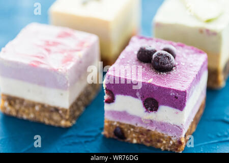 Hausgemachte rohe Kuchen mit frischen Beeren und Nüssen. Gesunde vegane Ernährung Konzept, aus der Nähe. Stockfoto