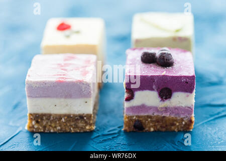 Hausgemachte rohe Kuchen mit frischen Beeren und Nüssen. Gesunde vegane Ernährung Konzept, aus der Nähe. Stockfoto