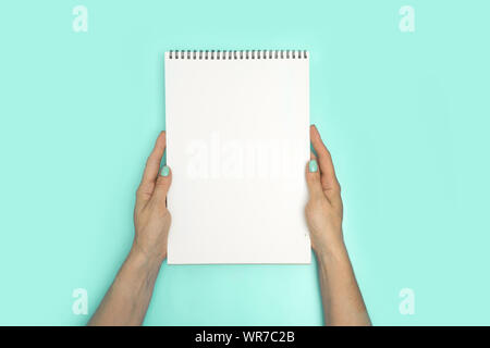 Frau Hände halten Skizzenbuch mit weißen Seite und leeren Raum für Text. Stockfoto