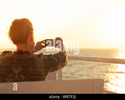 Kreuzfahrtschiff Urlaub junge Frau mit Sonnenaufgang auf Reisen auf dem Meer. Die Bilder von dem Meer auf einer Fähre. Stockfoto